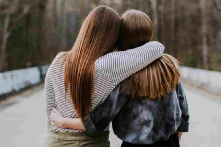 deux filles se tenant bras dessus bras dessous vue de dos