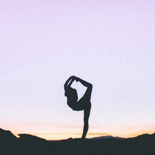femme en position de yoga au levé du soleil
