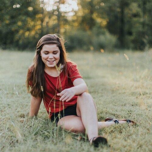 jeune fille assise dans l'herbe