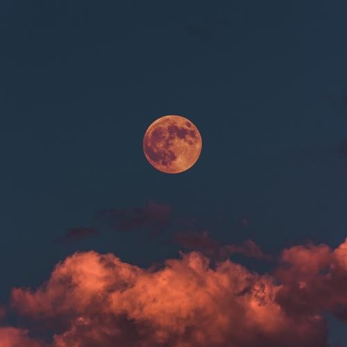 lune entourée de nuage dans un ciel rosé