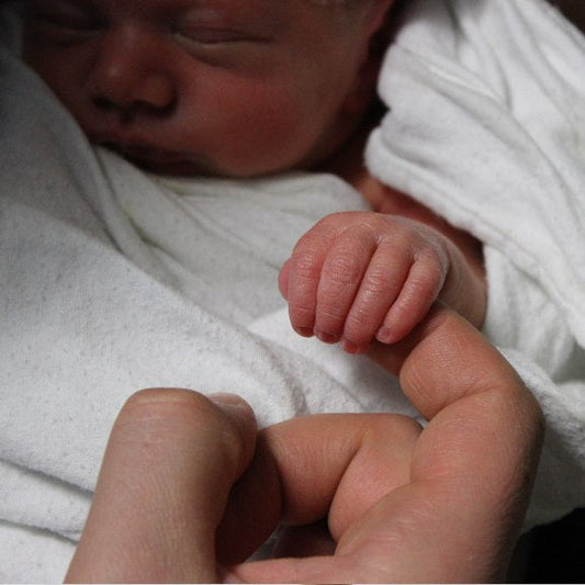 bébé qui tient le doigt de maman
