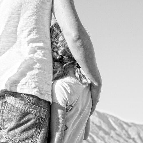 une mère sert sa fille contre elle