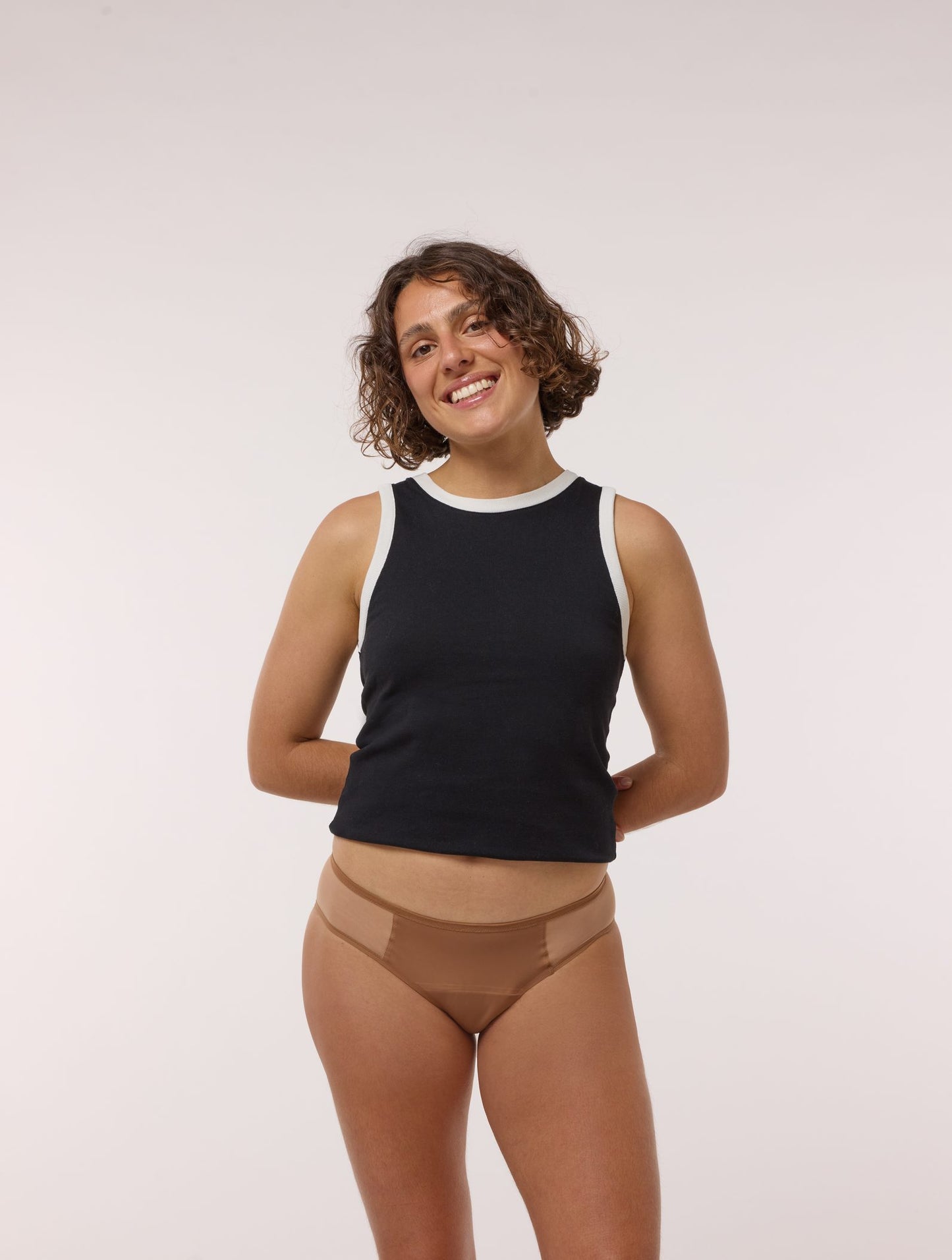 Femme souriante portant la culotte menstruelle Artémis Tulle nude, vue de face